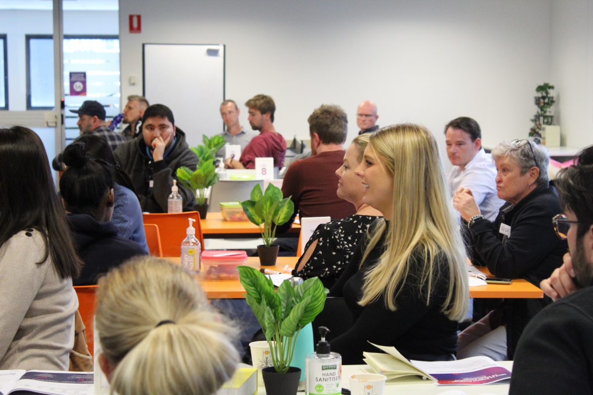 Business students seated at a presentation.