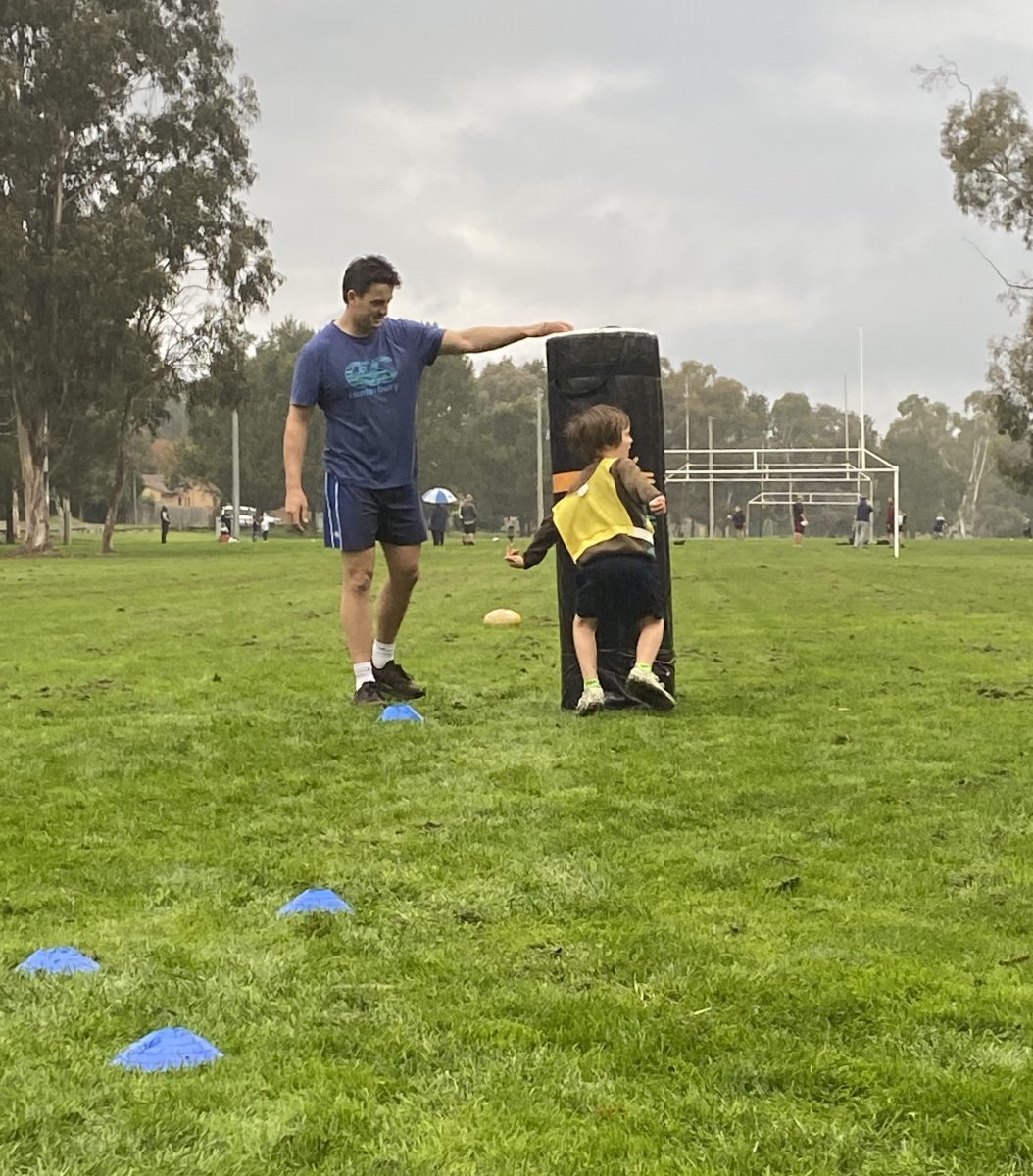 Young boy and trainer at Sense Rugby training session