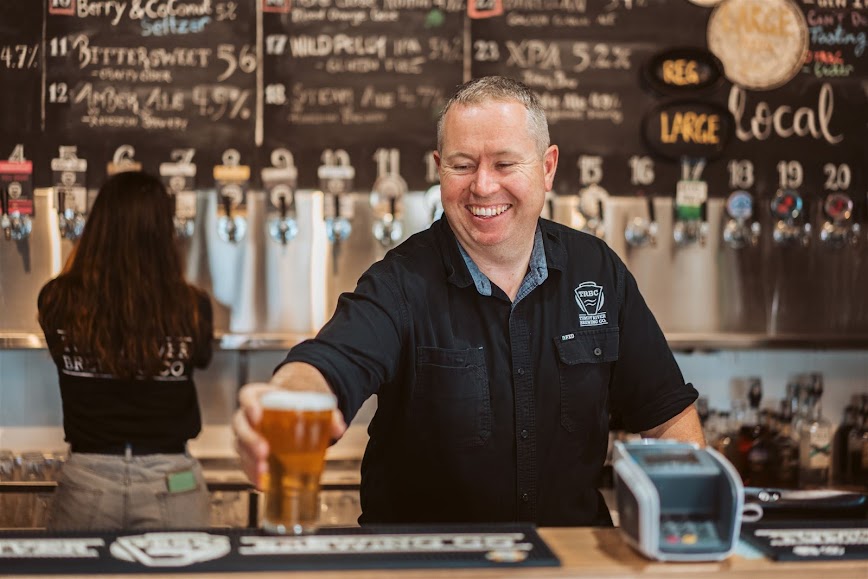 Tim Martin director Tumut River Brewing Co putting a beer on a bar