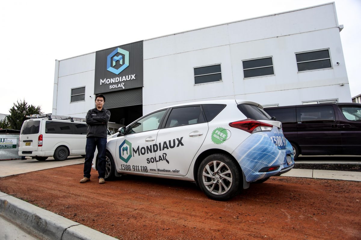 Mondiaux Solar's Leo Wang outside the business with a company car.