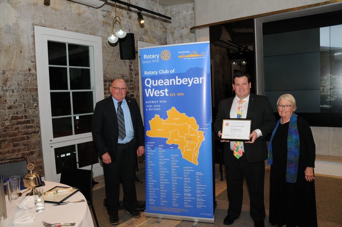 Three people in front of a banner