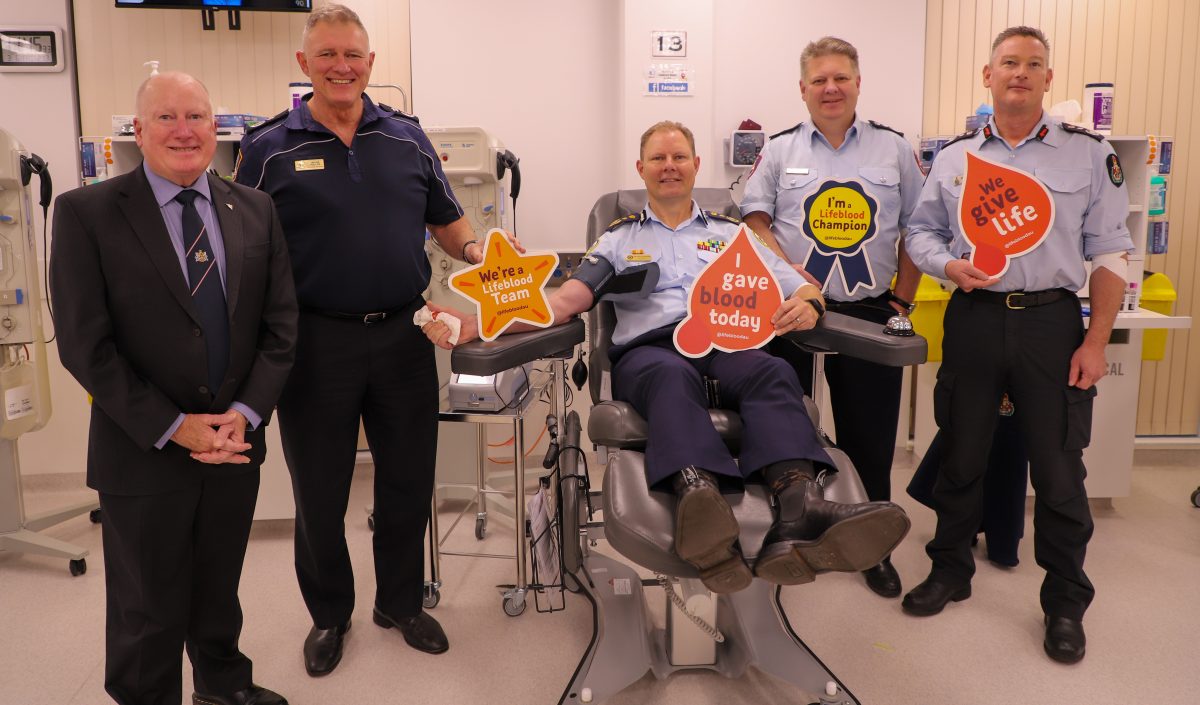 Five men hold up signs, including `I gave blood today'.