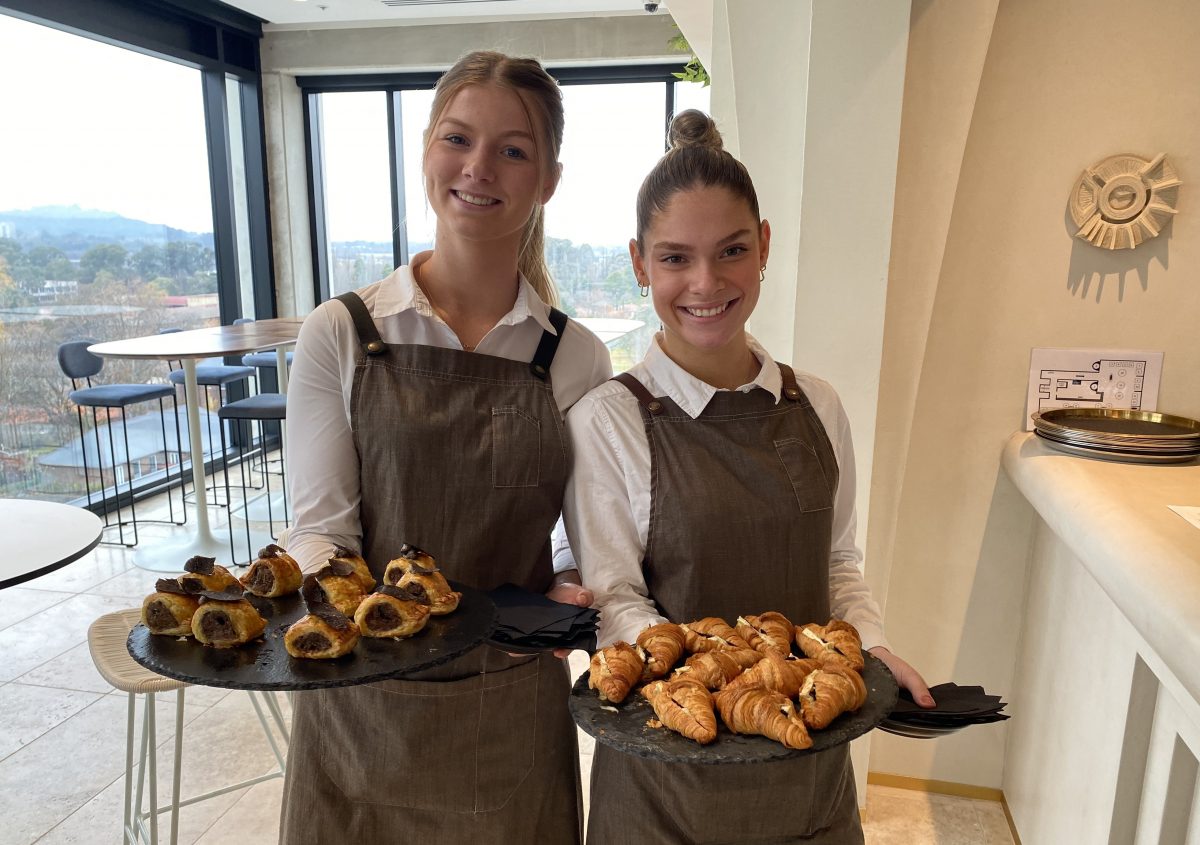 Two women holding food on trays