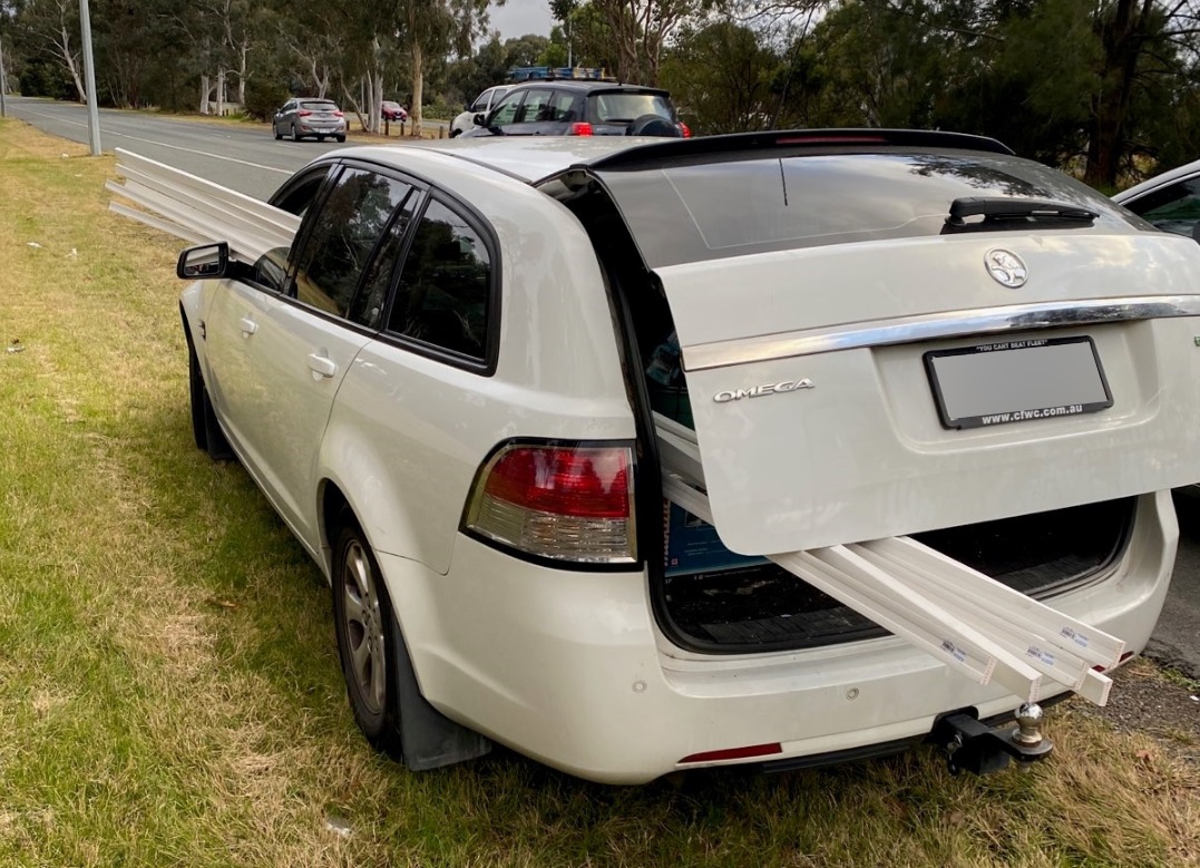 Long panels protrude from the boot and passenger window of a station wagon