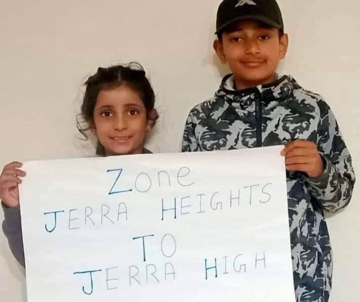 Two Jerrabomberra students hold a sign stating `Zone Jerra Heights To Jerry High'.