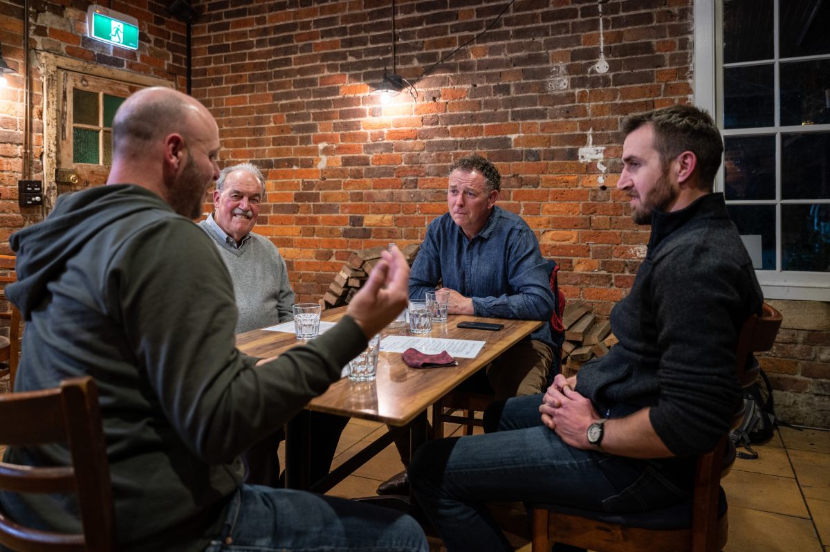 Men sitting around a table talking