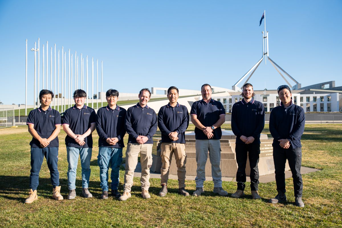 Tradies standing in front of Parliament house