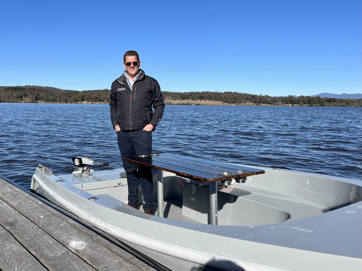 man standing in a boat on Lake Burley Griffin