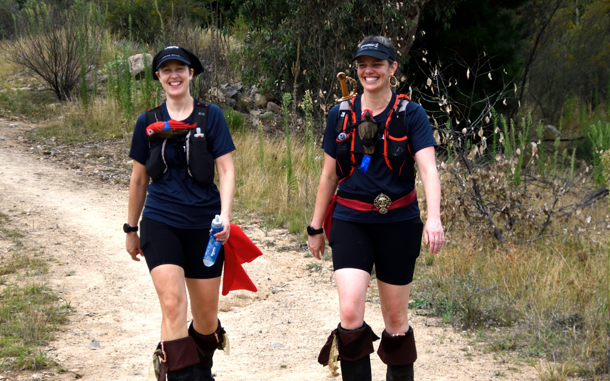 Two people walking on an outdoor trail on Mount Stromlo