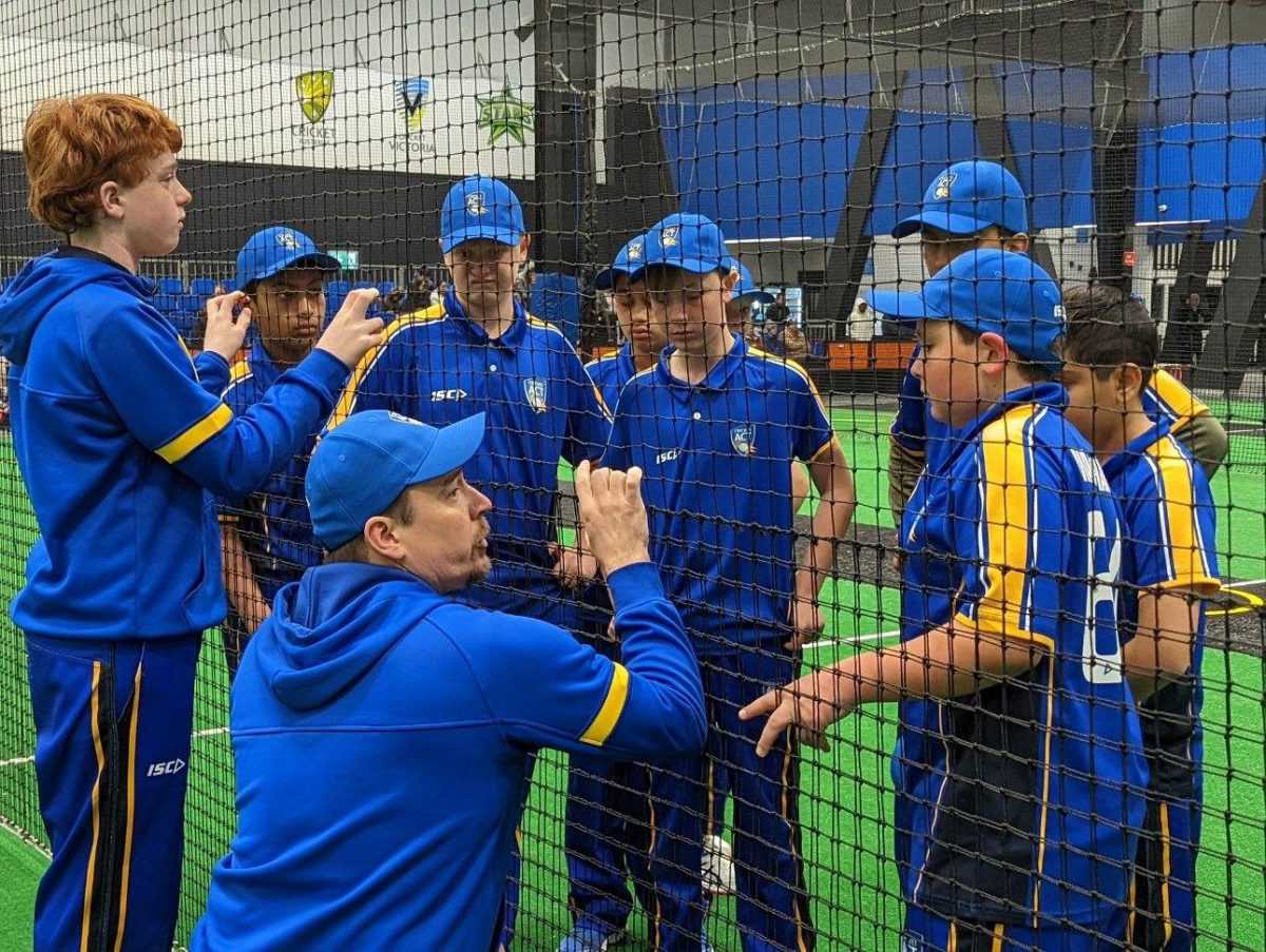 Young cricketers talking to their coach