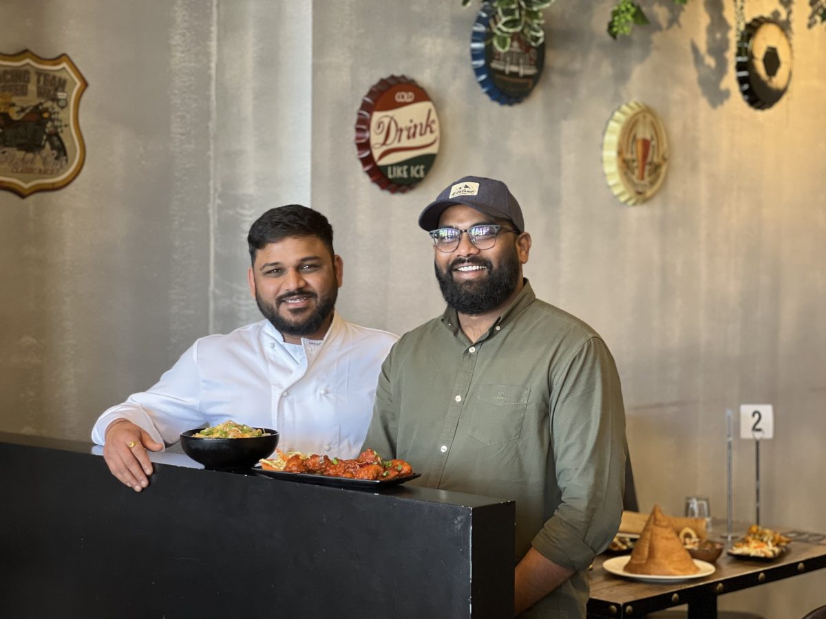 two men pose with food