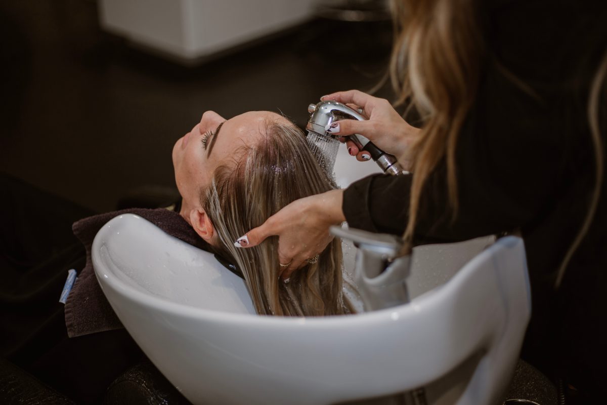 Woman getting their hair washed by hairdresser