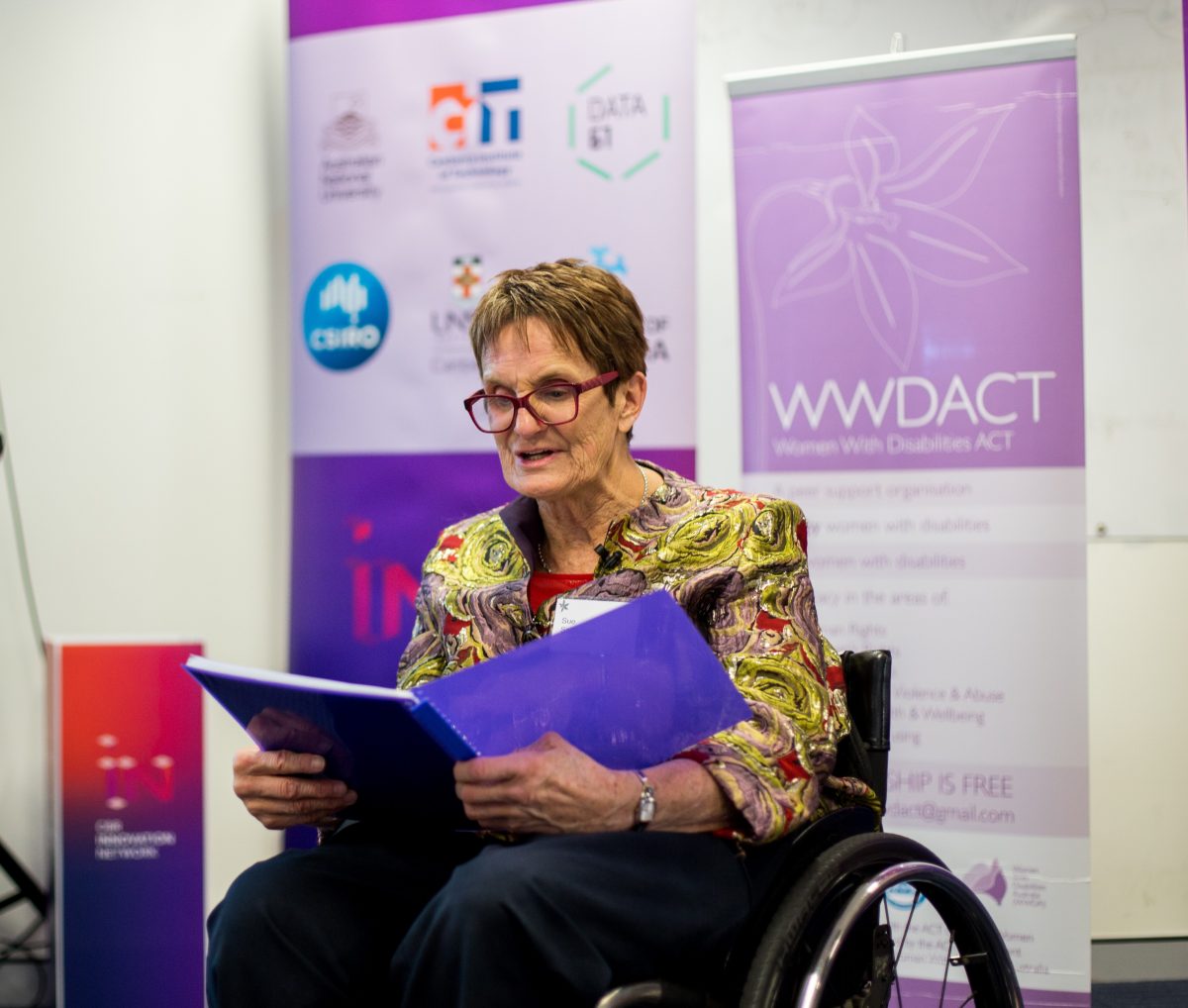 Disability advocate Sue Salthouse in a wheelchair reading