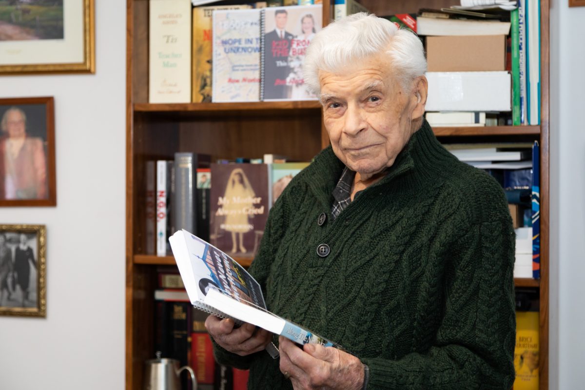 Ron Norton holding his books