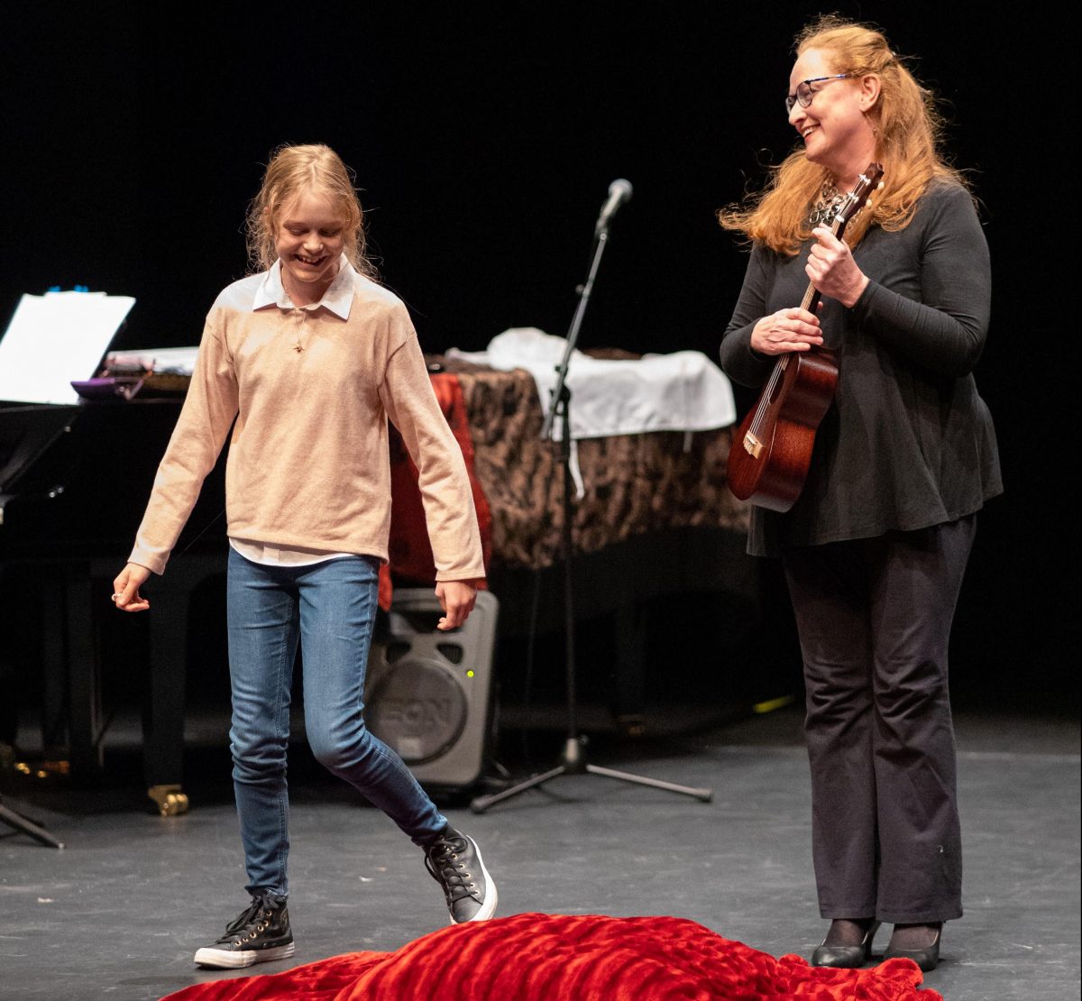 Music teacher Dianna Nixon on stage with a student