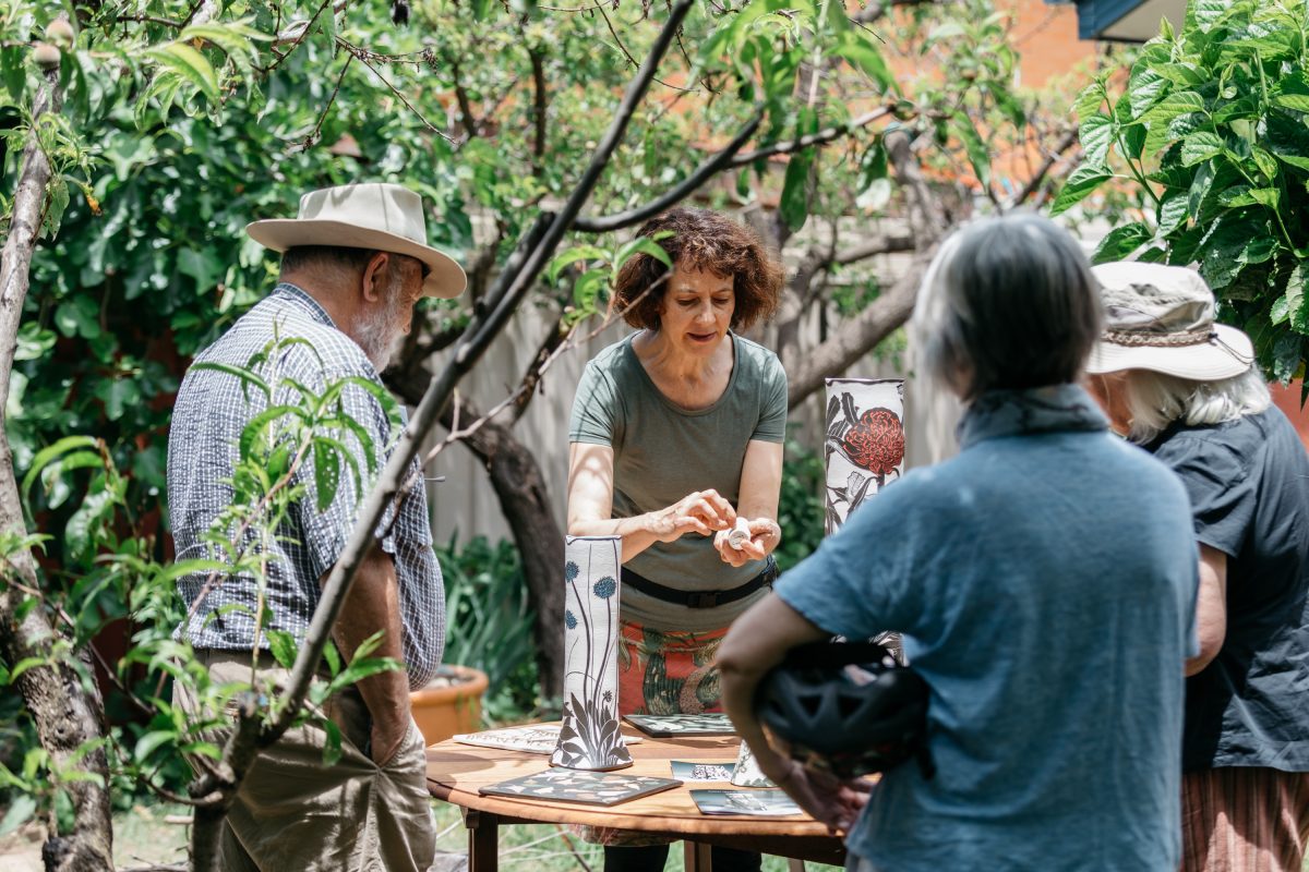 people in garden with pottery