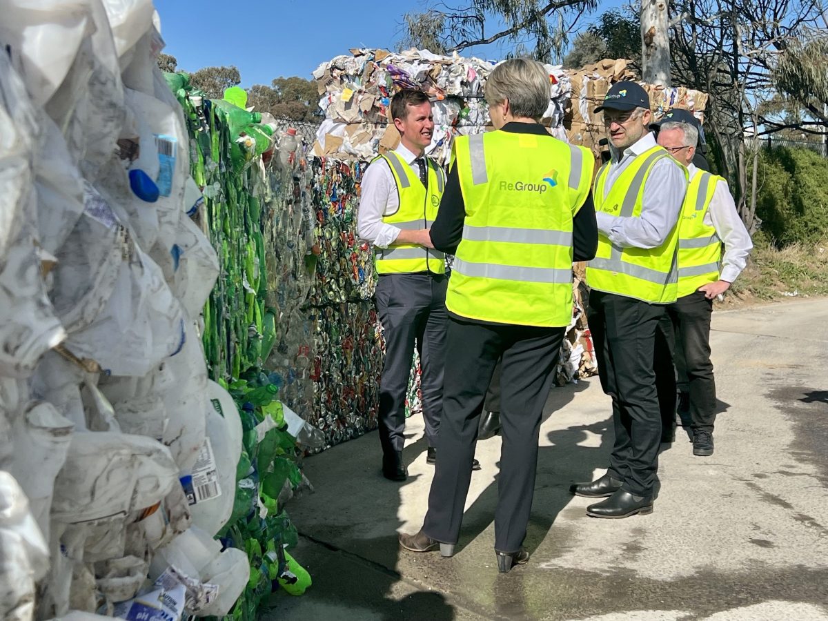 Chris Steel standing with people in high-vis at recycling centre