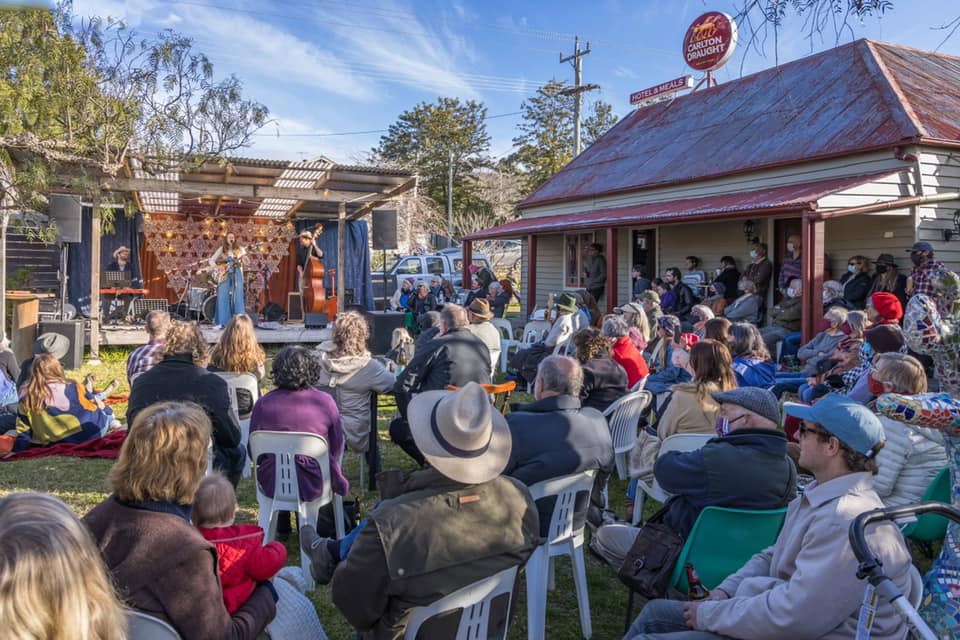 Group gathered on a law listening to a band on stage