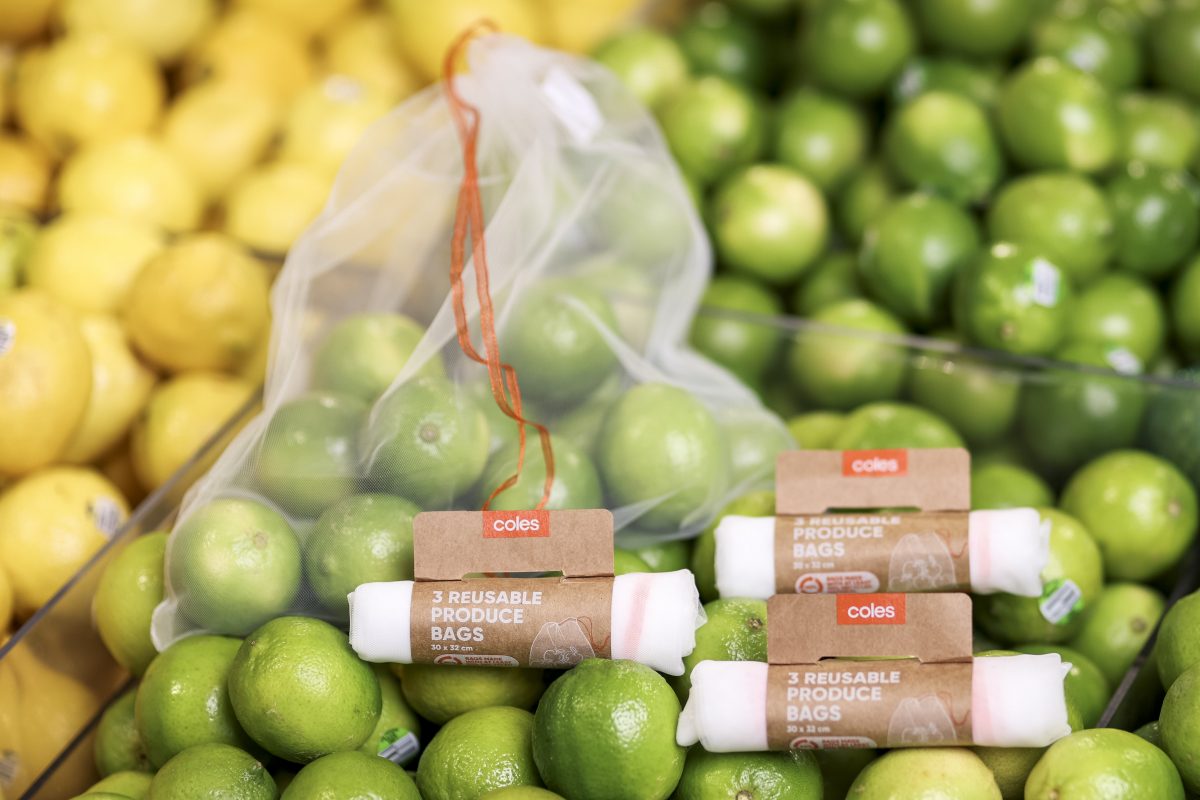 reusable bags sitting on top of lemons and limes