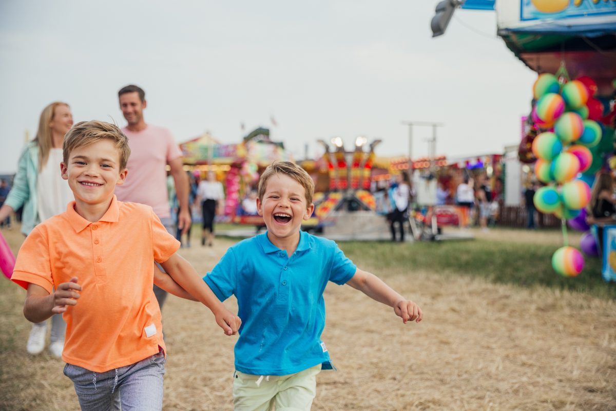 Family visit the fairground to enjoy the rides together