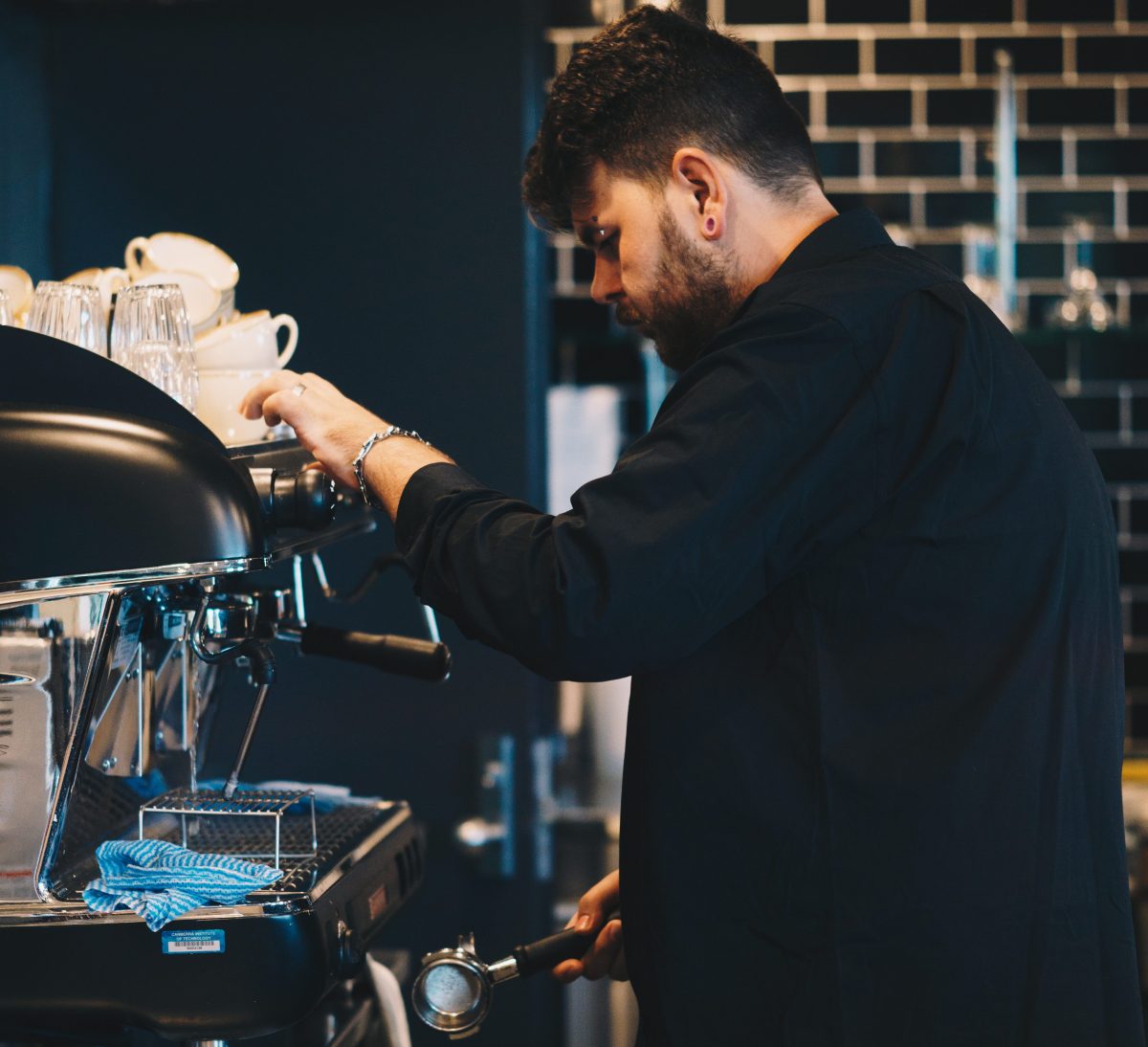 Barista at a coffee machine making coffee