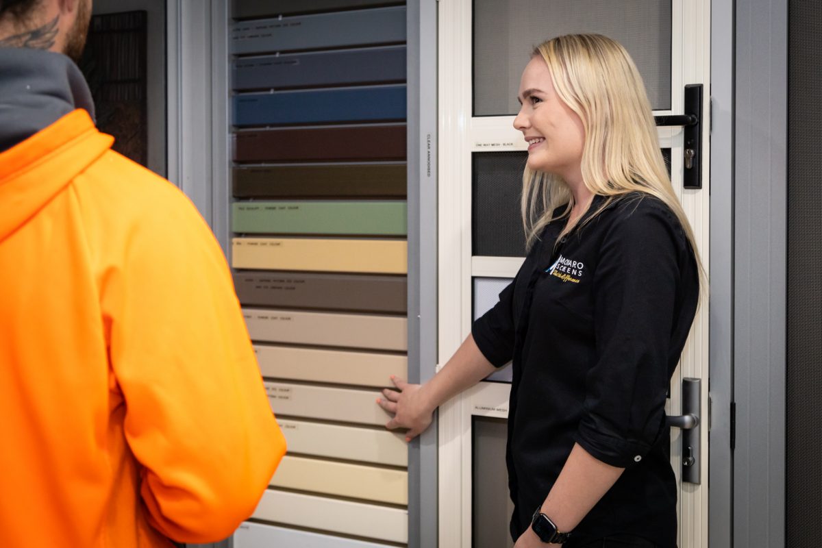 Monaro Screens employee shows samples to a customer in the showroom