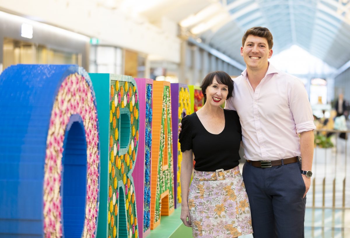 Man and woman near Lego sign