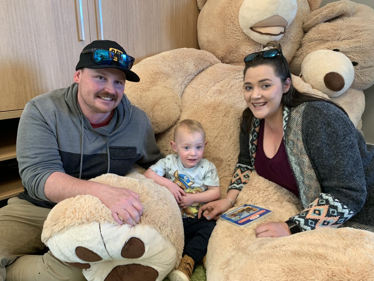 Family sitting with big teddy bear