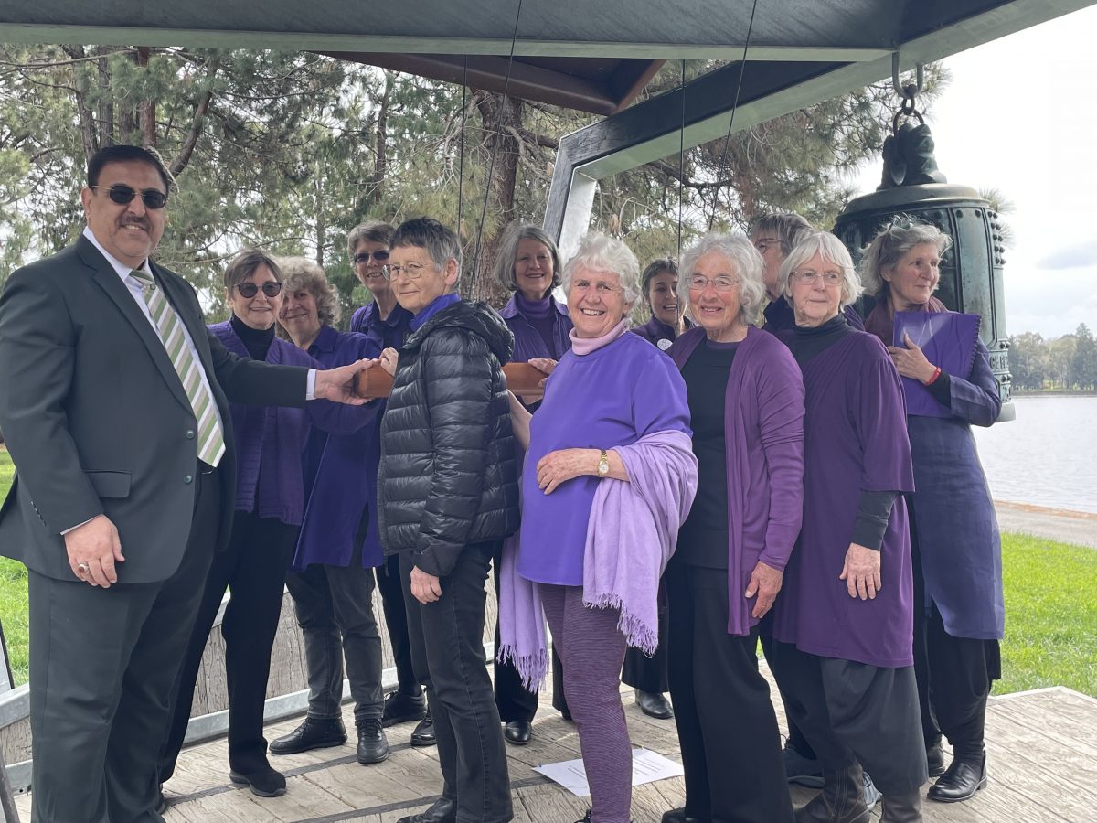 man and group of women ringing bell