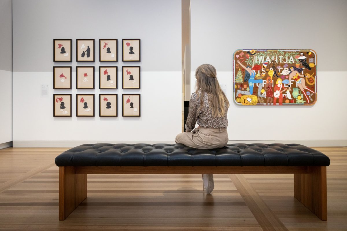 Woman sits on a bench in the national Portrait Gallery looking at artworks