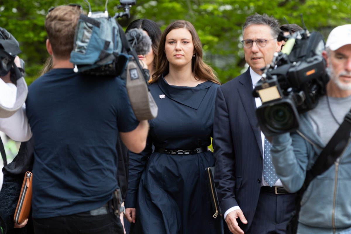 Woman walking to court surrounded by cameras