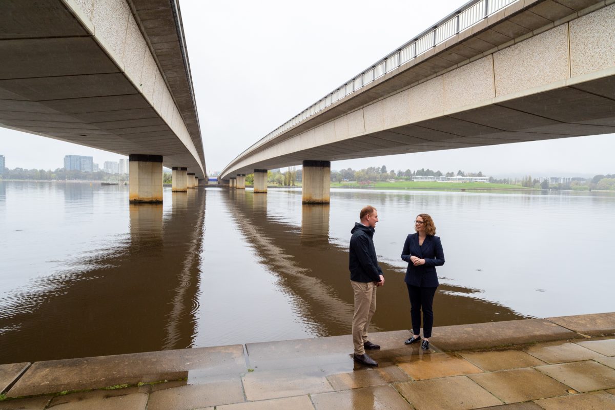 Man and woman standing under a bridge
