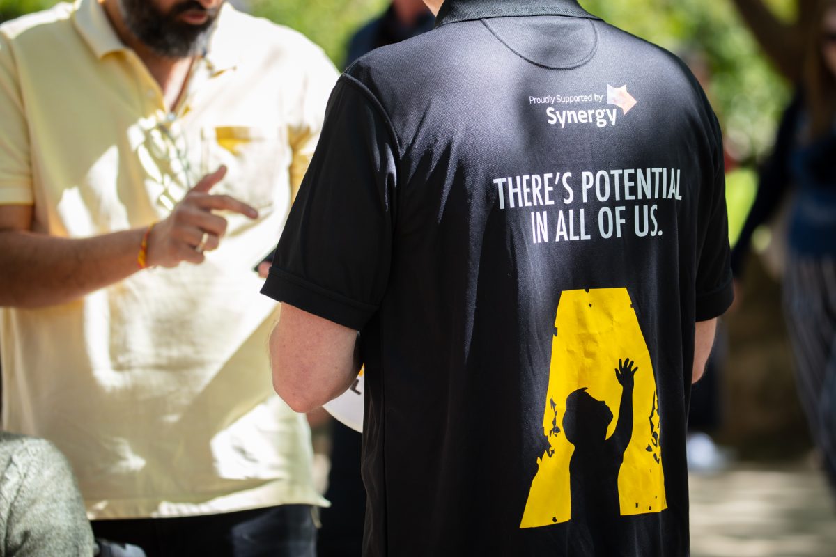 Raw Potential team member in black and yellow shirt that reads 'there's potential in all of us'