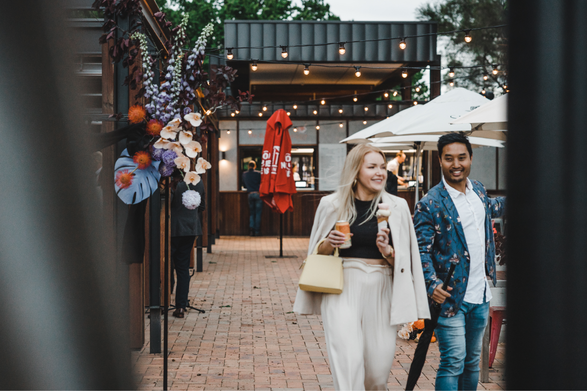 Two people walk away with gelato and drinks at Snapper and Co in Yarralumla