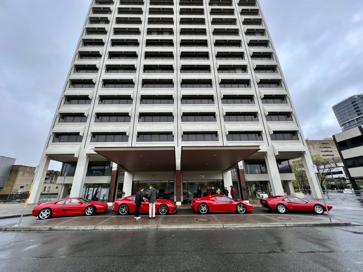 Red cars in front of a building