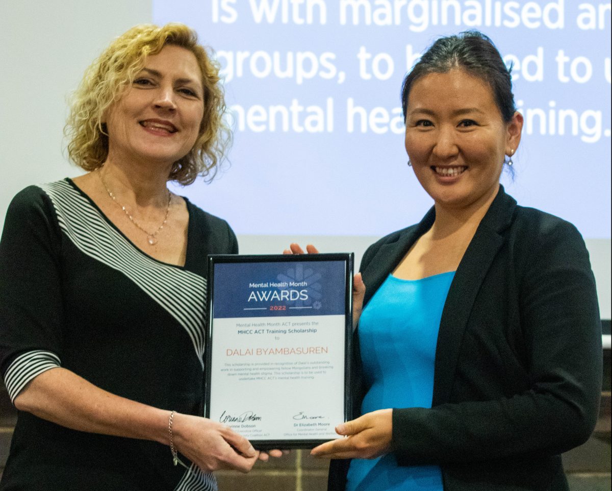 Two women holding an award