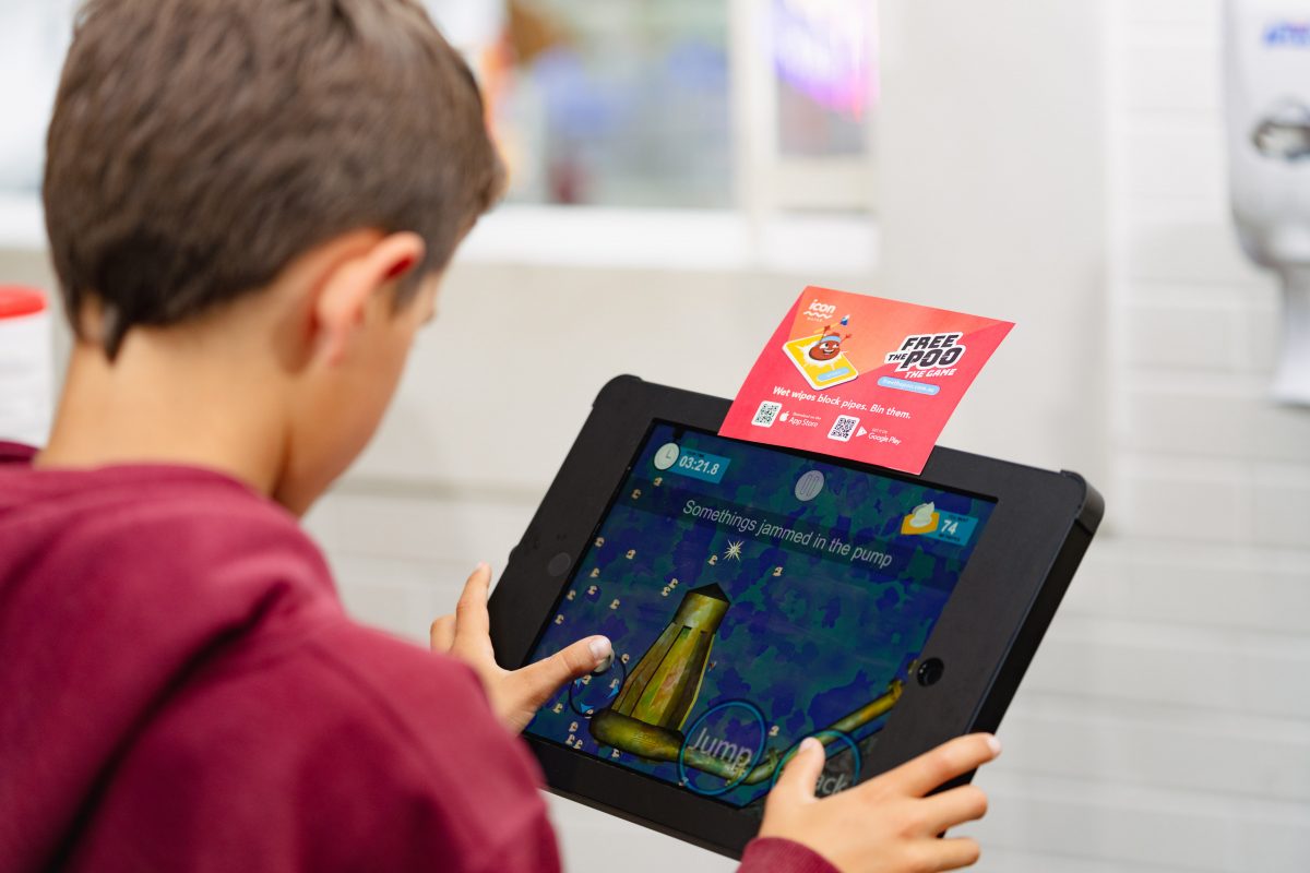A child on a tablet playing Icon Water's Free the Poo game