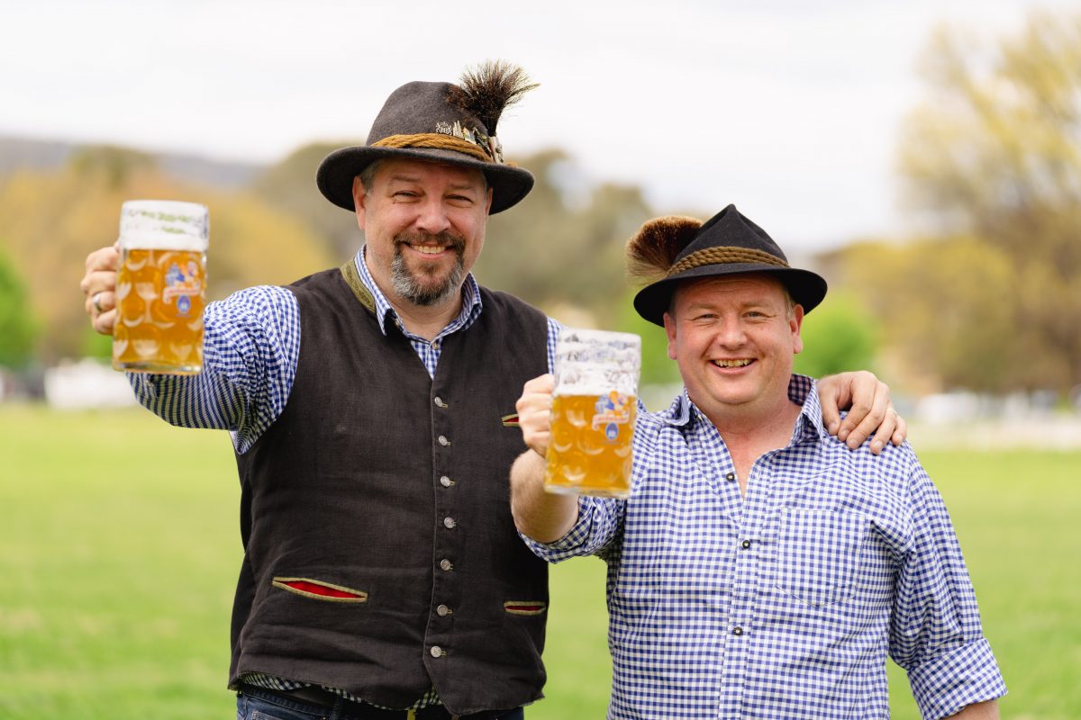Paul Berger and Josh Williams in traditional German dress holding jugs of beer