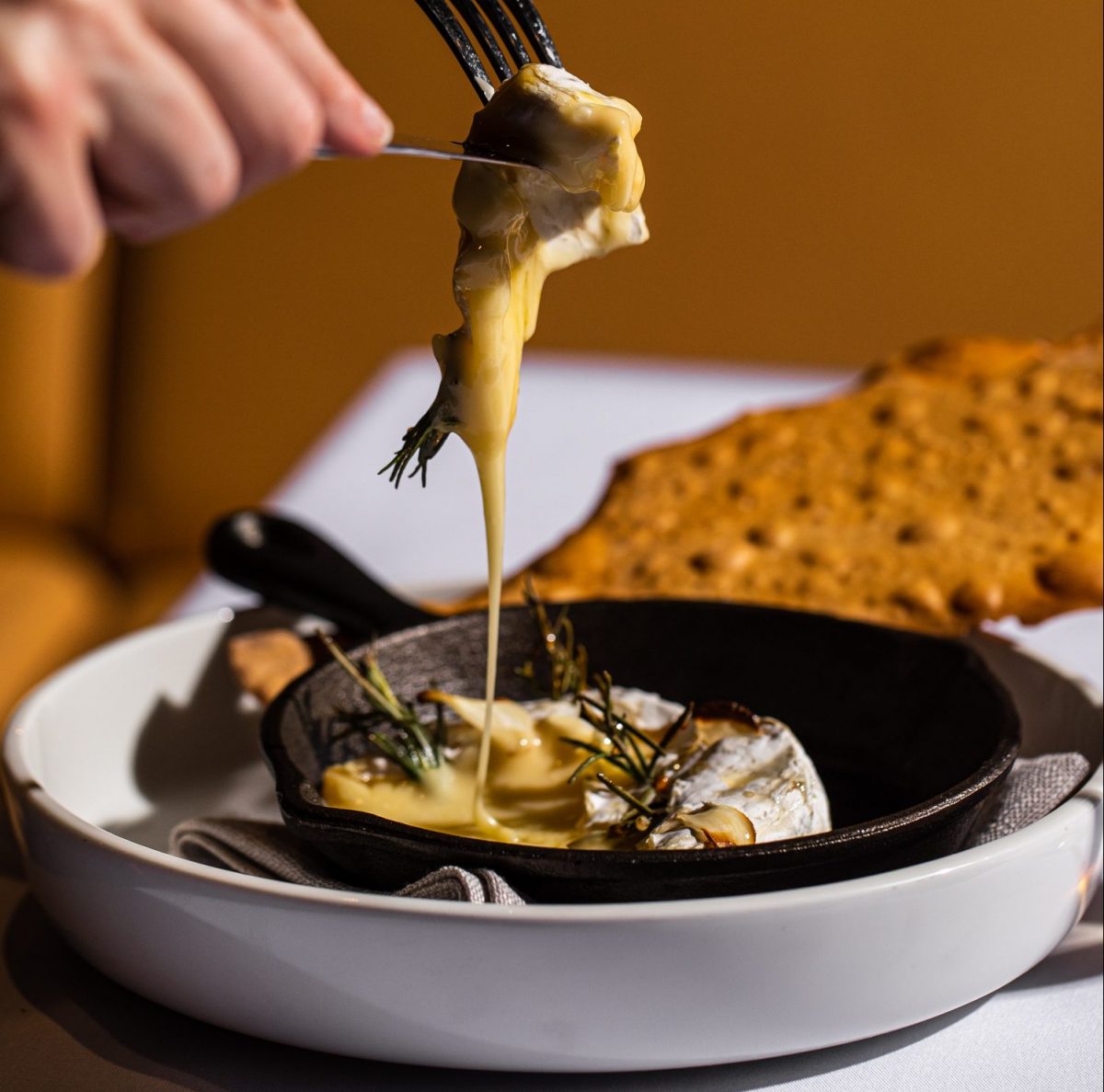 Baked camembert oozing from a knife and fork