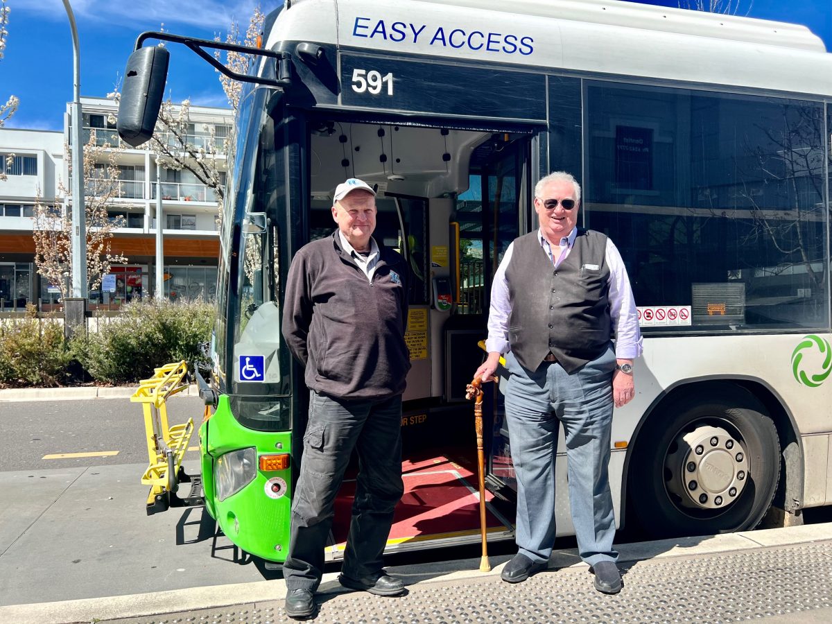 Two men in front of bus