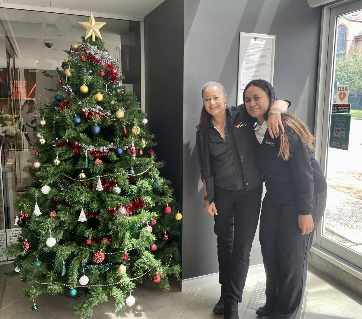 two women next to Christmas tree