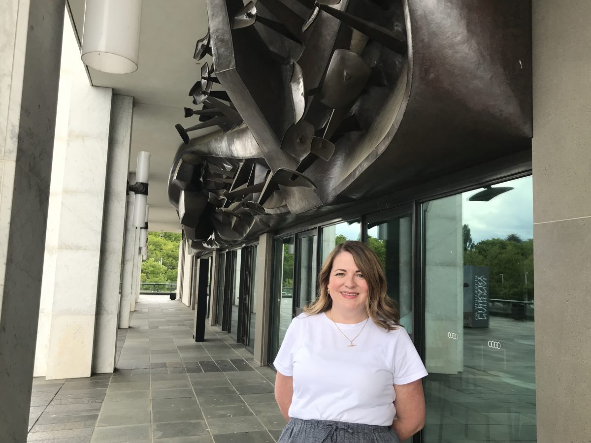 Amy with the 1968 Tom Bass Lintel Sculpture above the entrance to the National Library, containing three tonnes of copper