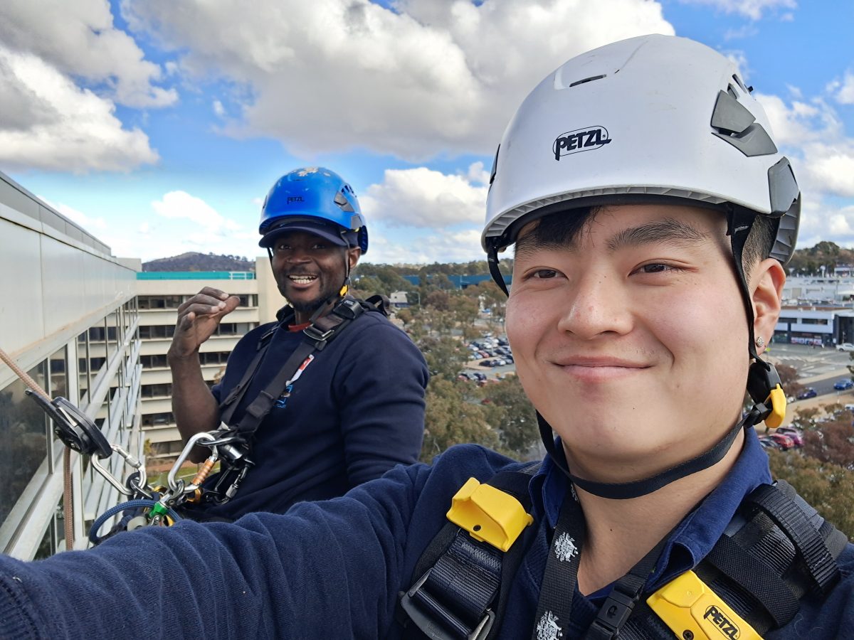 Two people climbing a building