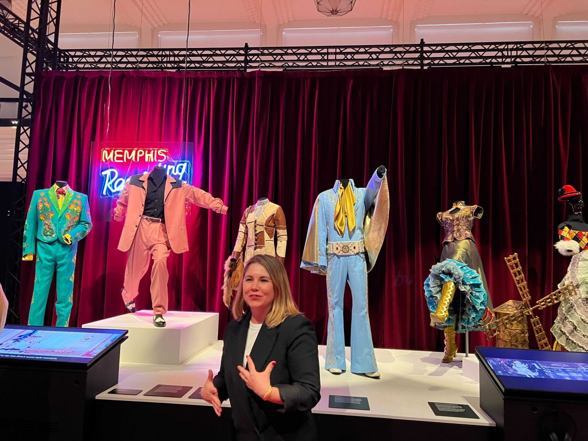 Woman in front of costumes and Memphis sign