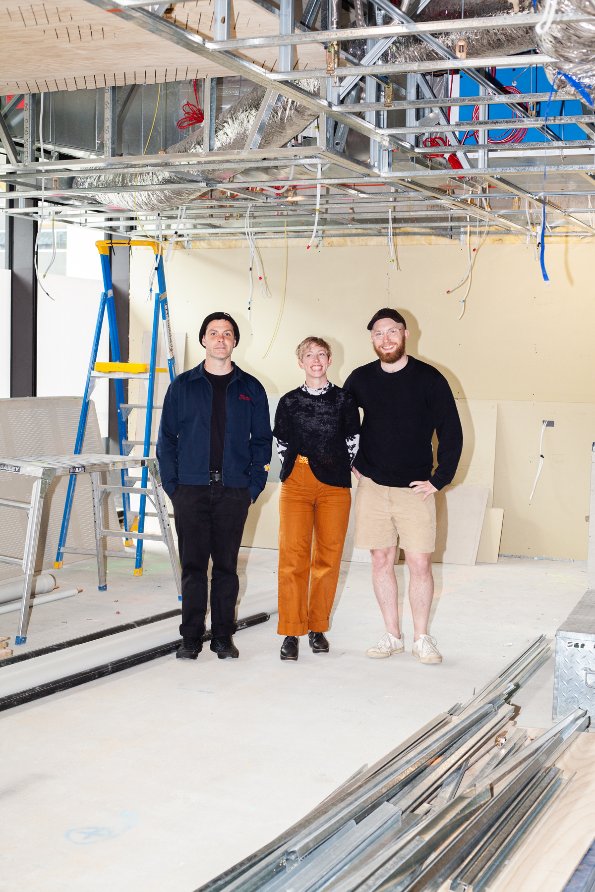 Woman and two men standing under building works