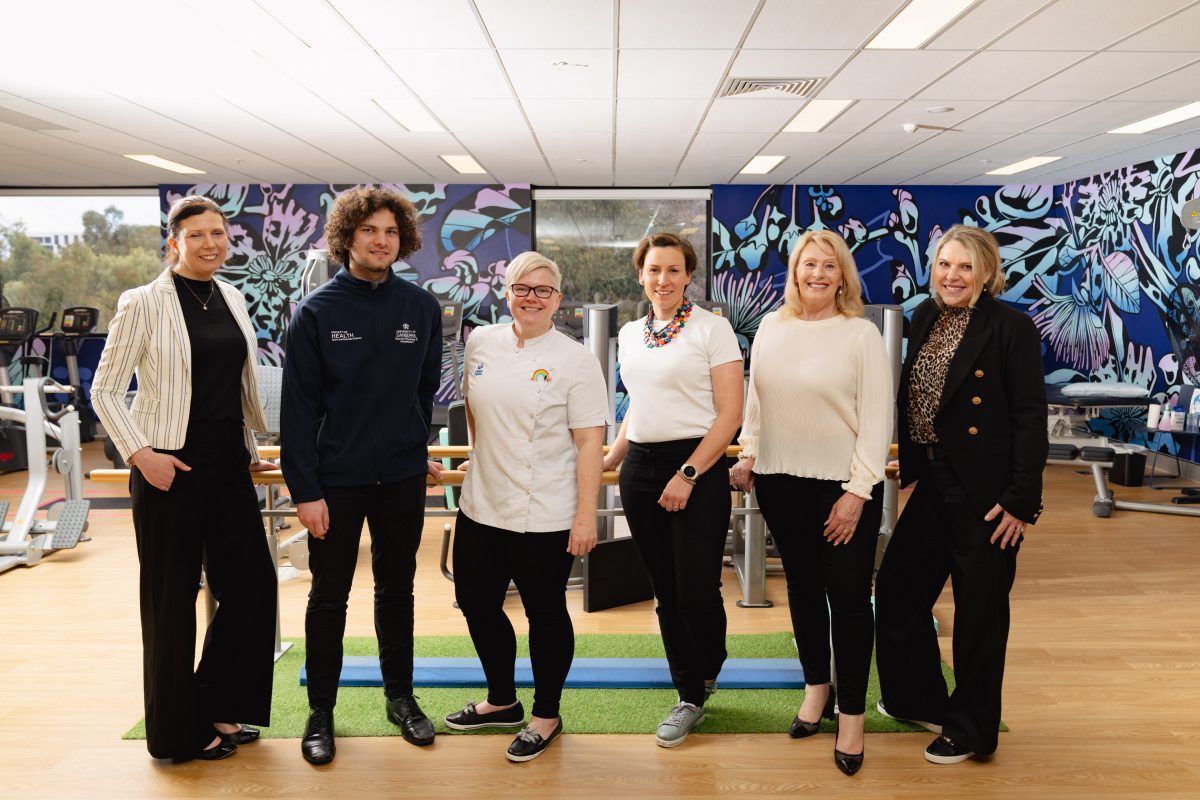 Melanie Moore, a UC student, Samantha Kourti, Cassandra Bennett, Melita Flynn and Amanda Fintan among a group of six people in an exercise room.