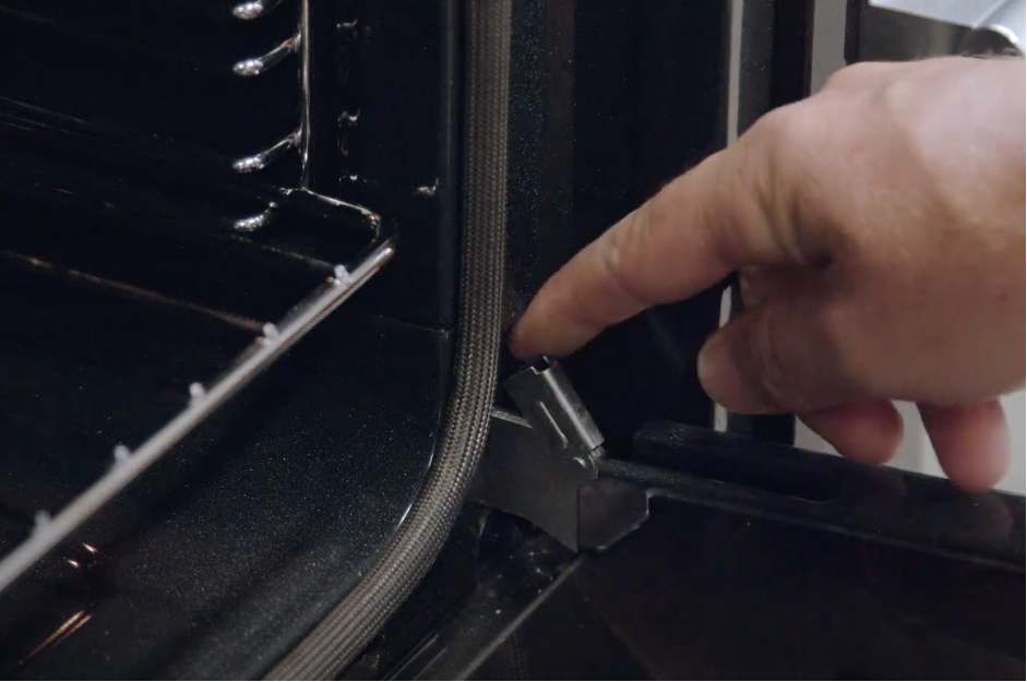 Grae Munro from Detlevs points to the hinge in an oven door to help with cleaning