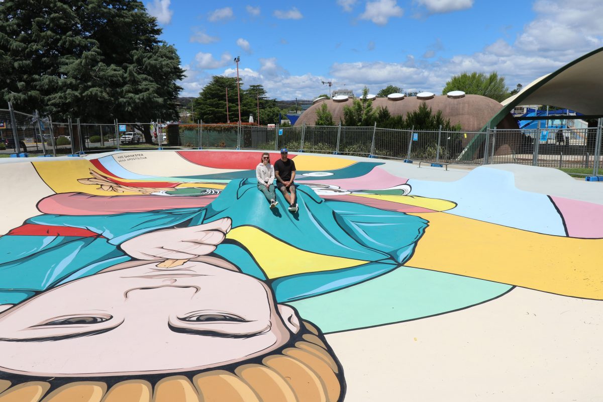 two people sitting at skatepark