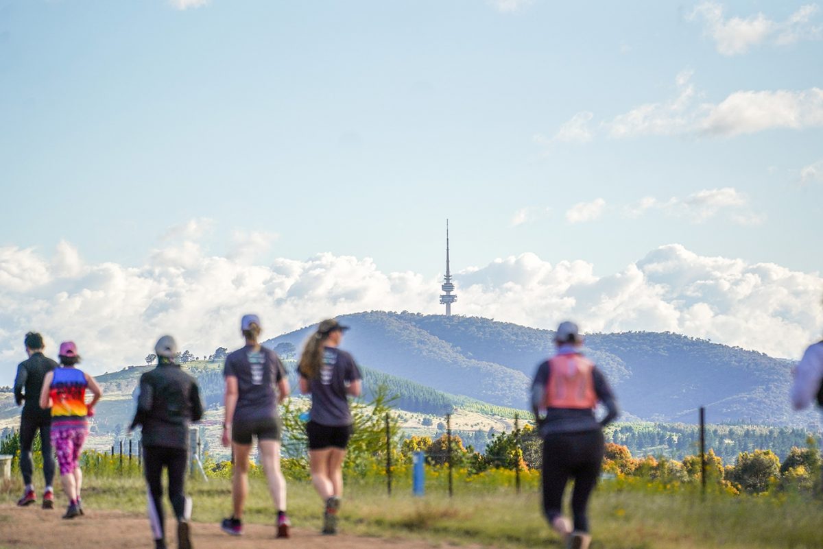 Runners in the foreground at the 2022 Stromlo Running Festiuval with Telstra Tower in the background