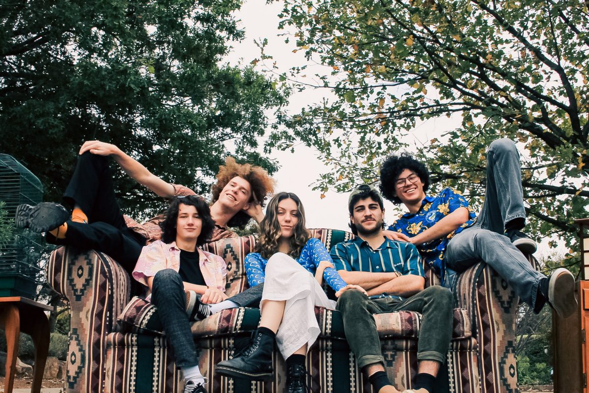 Five people sitting outdoors on a lounge 